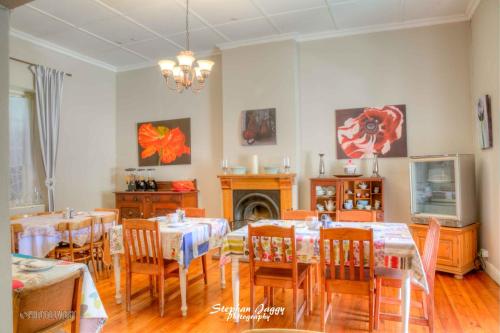a dining room with tables and chairs and a fireplace at Die Dorpshuis in Calitzdorp
