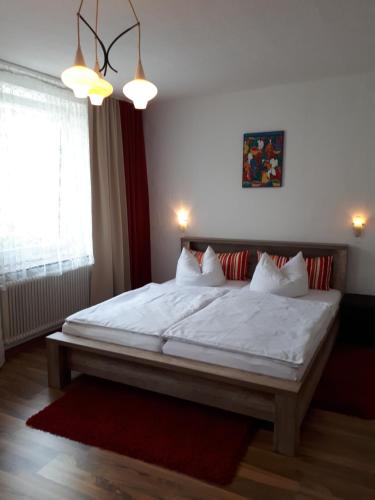 een slaapkamer met een groot bed met witte lakens en kussens bij Danka in Neukirchen beim Heiligen Blut