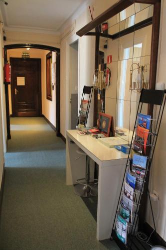 a room with a desk and a hallway with a door at Pensión Manoli in Bilbao