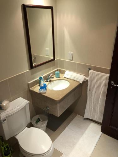 a bathroom with a sink and a toilet and a mirror at Studio Marina 2 in King Abdullah Economic City