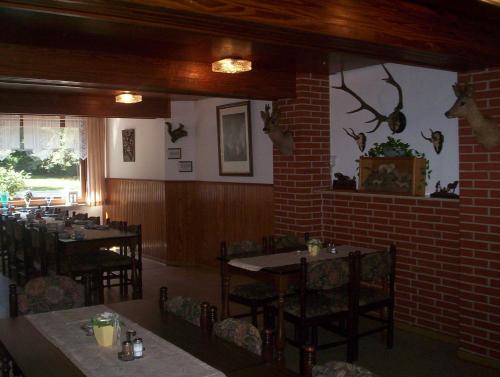 a restaurant with tables and chairs in a room at Pension Im Rehwinkel in Soltau