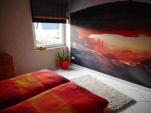 a bedroom with a large painting on the wall at Modernes Ferienhaus der besonderen Art mit Garten in Löhne