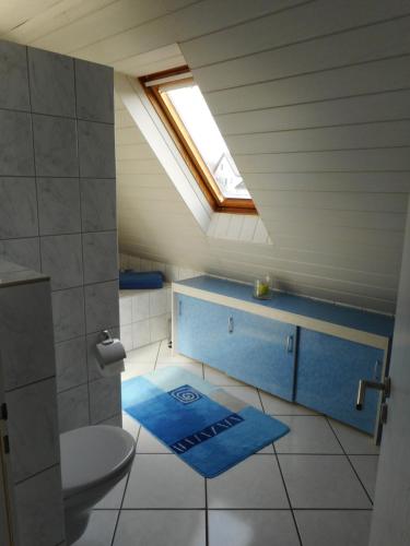 a attic bathroom with a toilet and a skylight at Modernes Ferienhaus der besonderen Art mit Garten in Löhne