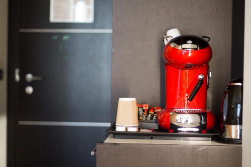 a red coffee maker sitting on top of a counter at Hotel Mercure Siracusa in Siracusa