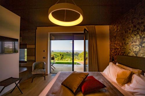 a bedroom with a bed with a view of a patio at Relais Le Rocche in La Morra