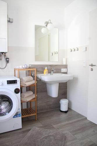 a bathroom with a sink and a washing machine at Ferienhaus Elisa in Petersfeld