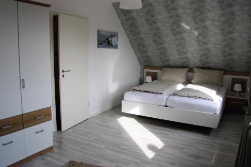 a bedroom with a white bed and a ceiling at Ferienhaus Elisa in Petersfeld