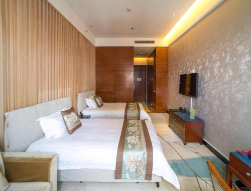a hotel room with two beds and a television at Guangzhou Nuomo International Hotel-Canton Fair Free Shuttle Bus in Guangzhou