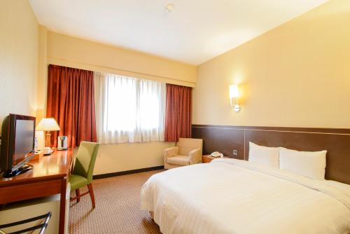 a hotel room with a bed and a desk at LA HOTEL- Liuhe Fusing in Kaohsiung