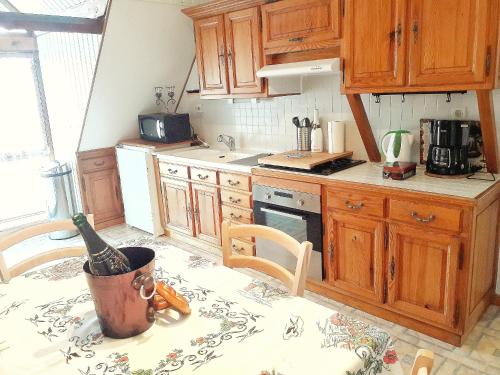 a kitchen with a table with a bottle of wine on it at Aux 6 hirondelles in Ammerschwihr