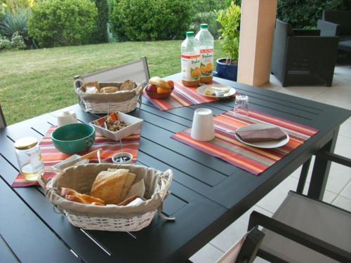 una mesa de picnic con pan y cestas de comida. en villa terrefort, en Drémil-Lafage