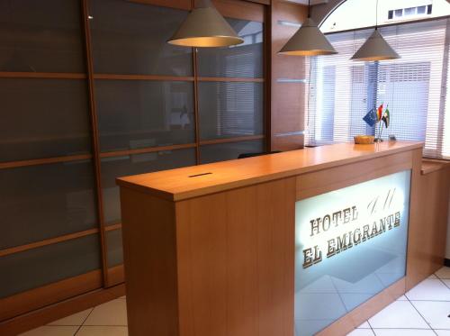 a reception desk with a sign on it at Hotel El Emigrante in Villanueva de la Serena