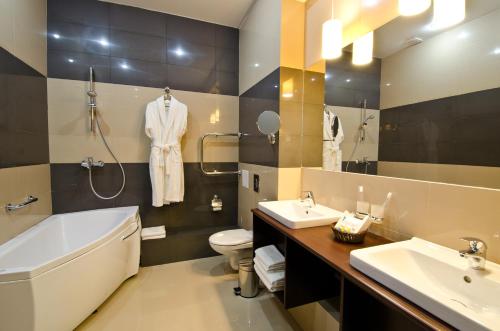 y baño con bañera, aseo y lavamanos. en Hotel City Star, en Perm