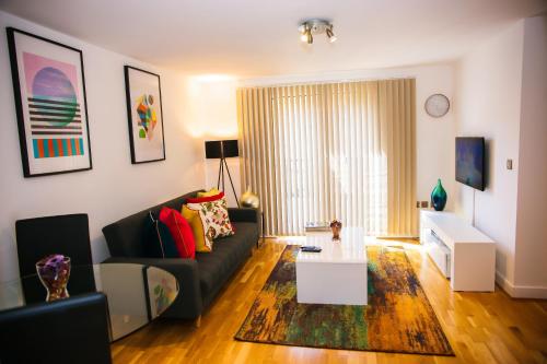 ein Wohnzimmer mit einem Sofa und einem Tisch in der Unterkunft Superior 2 bedroom Apartments in Woolwich