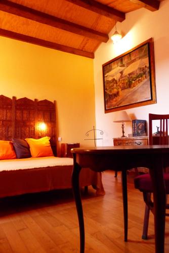 a bedroom with a bed and a desk and a table at L'orée du bois in Frayssinet-le-Gélat