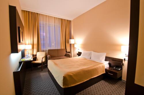 ペルミにあるHotel City Starのベッドと椅子付きのホテルルーム