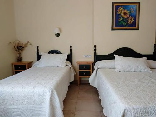 two beds sitting next to each other in a room at Hostal Almenara in Paterna del Madera