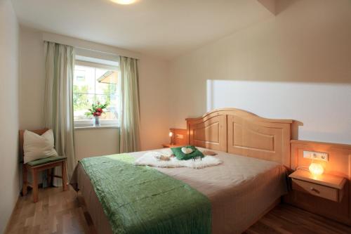 um quarto com uma cama com um urso de peluche em Haus Monika em Brixen im Thale