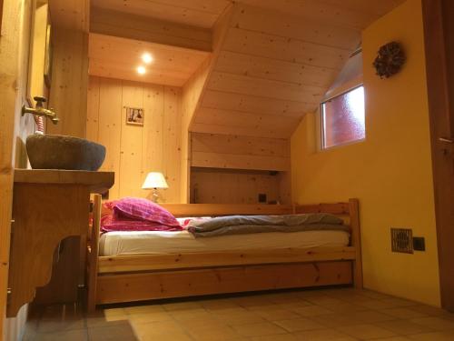 - une chambre avec un lit dans une cabane en rondins dans l'établissement Gite S'Hiesla, à Rammersmatt