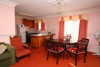 a living room with a table and chairs and a kitchen at Hatchers Richmond Manor in Richmond