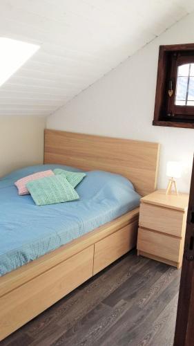 une chambre avec un lit avec une tête de lit en bois dans l'établissement location05220 duplex 6 lits, au Monêtier-les-Bains