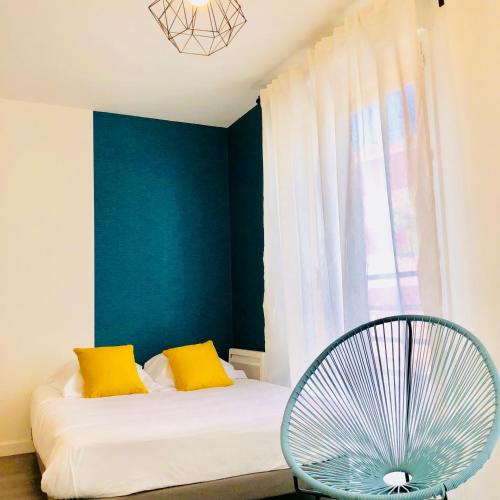 Cette chambre comprend un lit avec des oreillers jaunes et un ventilateur. dans l'établissement BtoBed - Location Professionnelle - Studio Confort Parking Gratuit Villepinte - Proche Parc des Expositions et Aéroport CDG, à Villepinte