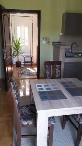 a kitchen with a wooden table and a dining room at Apartmani V&F in Vrnjačka Banja