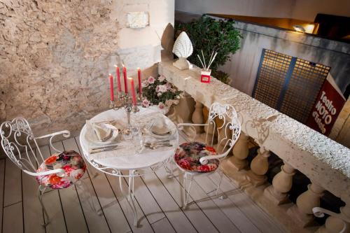 a white table and chairs with candles on it at à Marchisa -Noto- in Noto