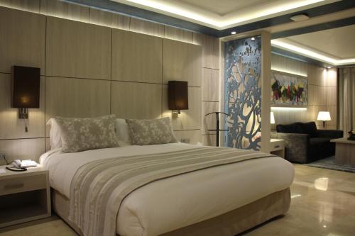 Zaki Suites Hotel & Spa في مكناس: غرفة نوم بسرير كبير وغرفة معيشة