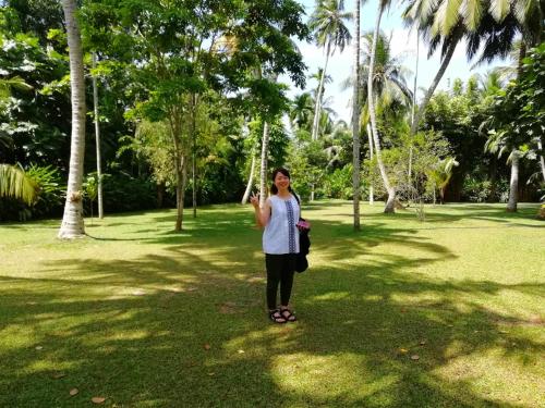a woman standing on a swing in a park at Old Parkland Hostel in Galle