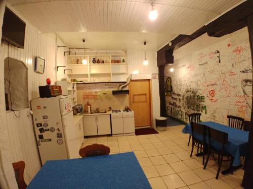 サラエボにあるリュビチカホステルのキッチン(白い家電製品、青いテーブルと椅子付)