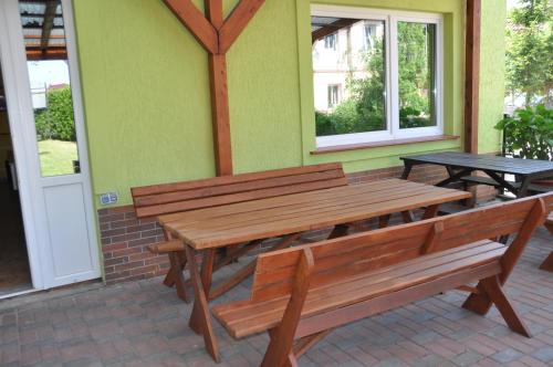 a patio with two benches and a table and windows at Budziar - kwatery nad morzem in Darłowo