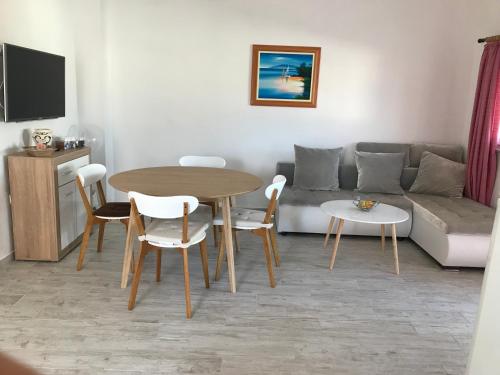 a living room with a table and a couch at Apartmani Darija in Vir
