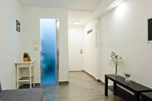 a hallway with a blue door and a table at Stunning Studio By The Beach With Free Parking in Tel Aviv