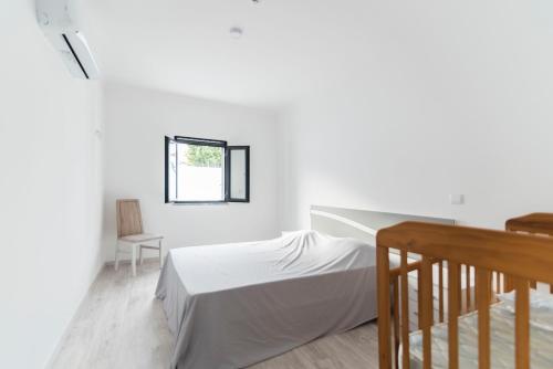 Un dormitorio blanco con una cama y una ventana. en Villa UA, en Pias