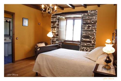 a bedroom with a bed and a brick wall at Casa Rural Vila Pomar in Ribadeo