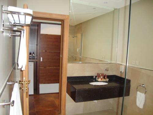 a bathroom with a sink and a mirror at Milan Deluxe Suites in Al Khobar