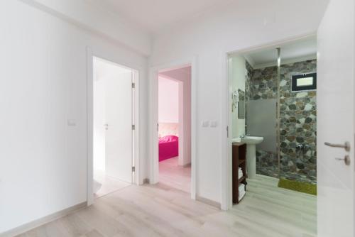 Baño blanco con pared de piedra en Villa UA, en Pias