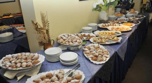 a long table with plates and bowls of food on it at Hotel Panoramic in Giardini Naxos