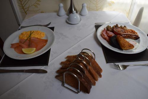 twee borden ontbijtproducten op een tafel bij Cedar Lodge in Llandudno