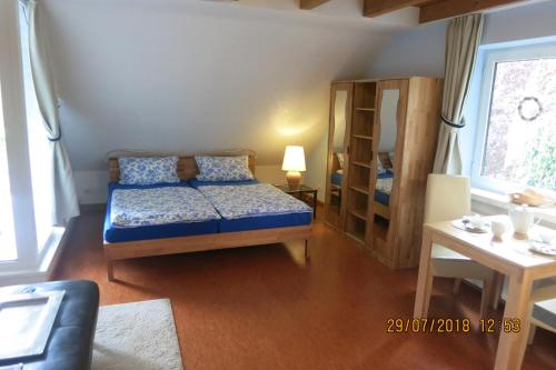 ジンツィッヒにあるWildgartenのベッドルーム1室(青いベッド1台、枕、テーブル付)
