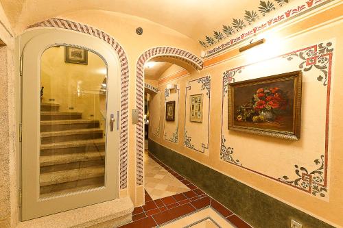 a hallway with stairs and a painting on the wall at Hotel Krčínův Dům in Český Krumlov