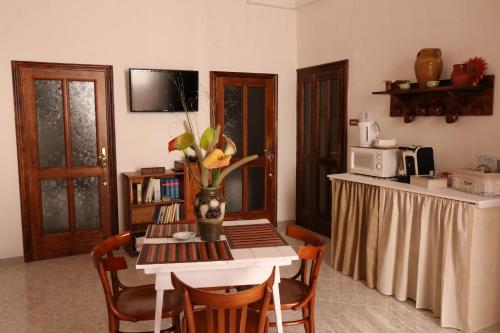 a kitchen with a table with a vase of flowers on it at Casa Antica in Fasano