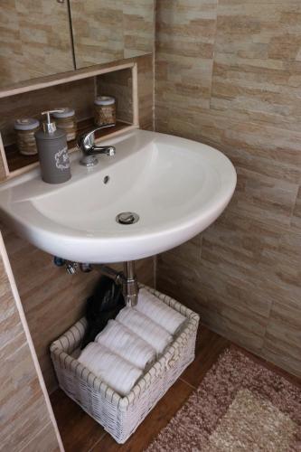 a sink in a bathroom with a basket under it at Casa Antica in Fasano