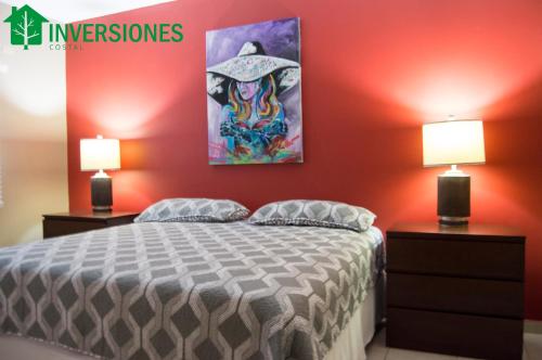 a bedroom with a bed with two night stands and two lamps at Apartamento Corporativo in San Pedro Sula