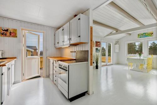uma cozinha com armários brancos e um piso branco em Teibernveien 86, Larkollen (Rygge, Norways) em Rygge
