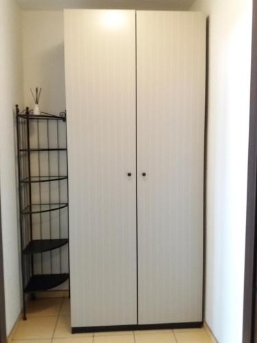 Armario blanco con 2 puertas en una habitación en Apartament, en Hajnówka