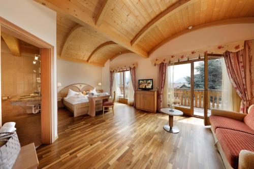una gran sala de estar con techo de madera. en Hotel Weingarten, en Appiano sulla Strada del Vino