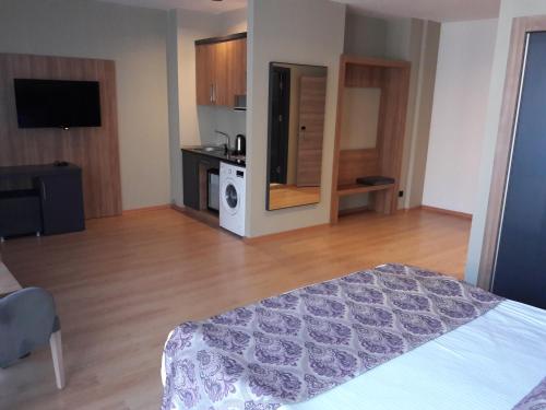 a large room with a bed and a kitchen at Euphoria Apartments in Batumi