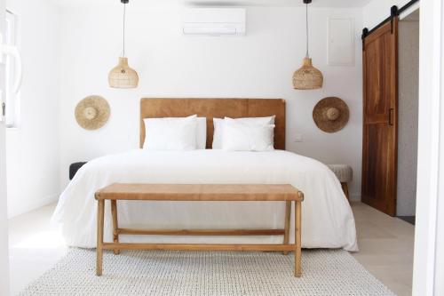 a bedroom with a white bed with a wooden headboard at Luxury Family Beach Front Villa - SUNDAY BEACH HOUSE in Slatine